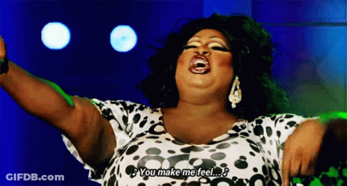 A Drag Queen Is Singing Into A Microphone And Saying `` You Make Me Feel '' GIF