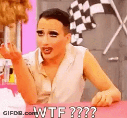 A Drag Queen Is Sitting At A Table Making A Funny Face And Saying `` Wtf '' . GIF