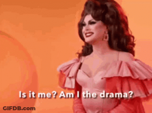 A Drag Queen Is Standing In Front Of An Orange Background And Asking Is It Me ? Am I The Drama ? GIF