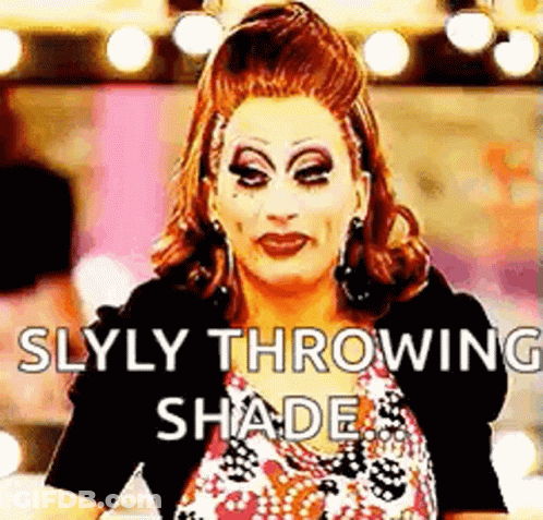 A Drag Queen Is Throwing Shade At The Camera While Wearing Makeup . GIF