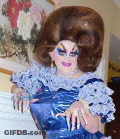 A Drag Queen Is Wearing A Blue Dress And Has A Very Large Wig On GIF