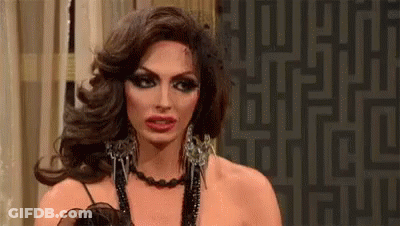 A Drag Queen Is Wearing A Necklace And Earrings And Making A Face . GIF