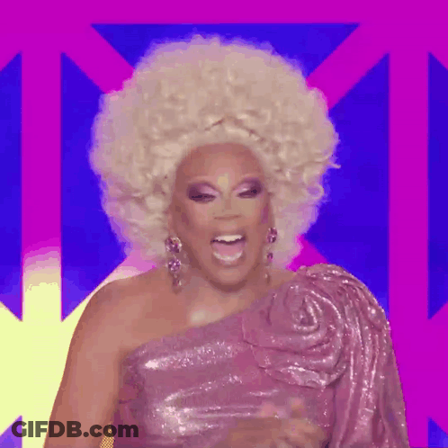 A Drag Queen Is Wearing A Pink One Shoulder Dress And A Large Blonde Afro Wig . GIF