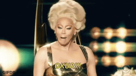 A Drag Queen Is Wearing A Wig And A Gold Dress And Says Oku !!! GIF