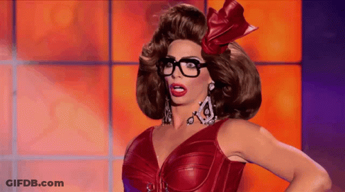 A Drag Queen Is Wearing Glasses And A Red Dress GIF