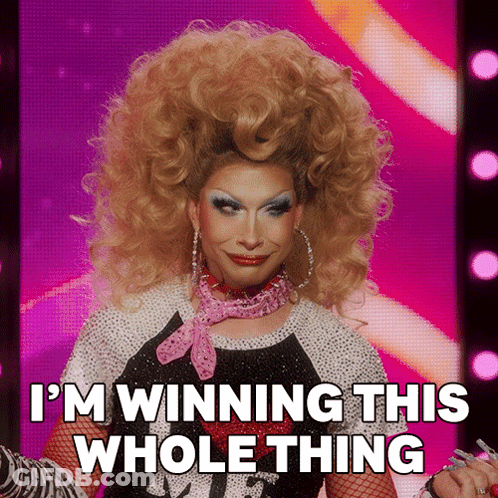 A Drag Queen Says " I 'M Winning This Whole Thing " On A Pink Background GIF