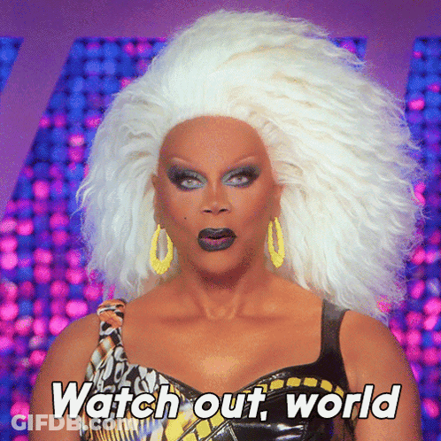 A Drag Queen Says " Watch Out World " While Wearing A Wig GIF