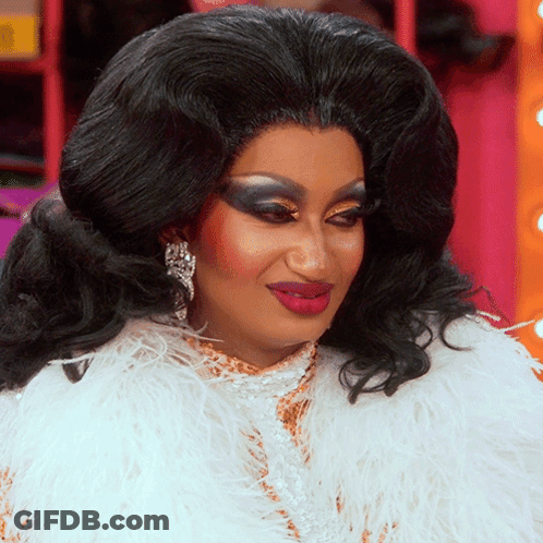 Drag Queen In White Feathered Coat And Earrings GIF