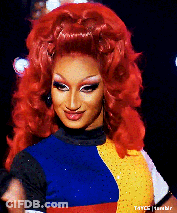 Drag Queen With Red Hair Smiling In Colorful Outfit GIF