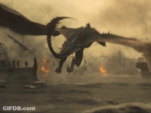 A Dragon Is Flying Over A Burning City With A Few People Standing In The Background GIF