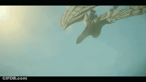 A Dragon Is Flying Through The Air With Its Wings Spread . GIF