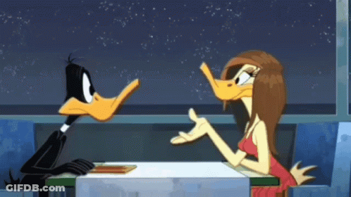 A Duck And A Woman Are Sitting At A Table In A Diner GIF