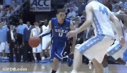 A Duke Basketball Player Is Dribbling The Ball While Another Player Tries To Stop Him GIF