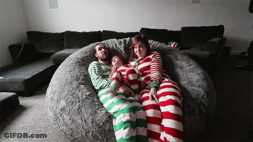 A Family Is Laying On A Bean Bag Chair Wearing Striped Pyjamas GIF