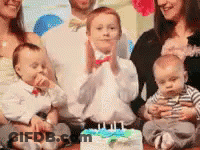 A Family Is Posing For A Picture In Front Of A Birthday Cake . GIF