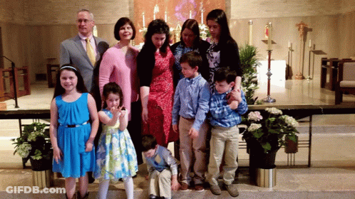 A Family Posing For A Picture In Front Of A Church Altar GIF