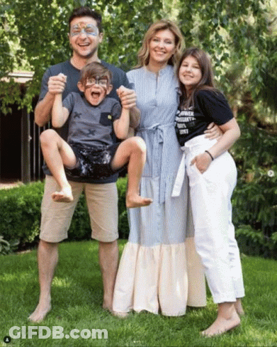 A Family Posing For A Picture With One Of The Children Wearing A Shirt That Says ' Power ' GIF