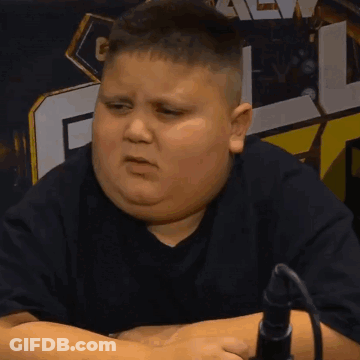 A Fat Boy In A Black Shirt Is Sitting In Front Of A Microphone And Making A Face GIF