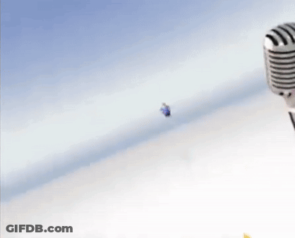 A Fat Cartoon Character Is Flying Through The Air Next To A Microphone . GIF