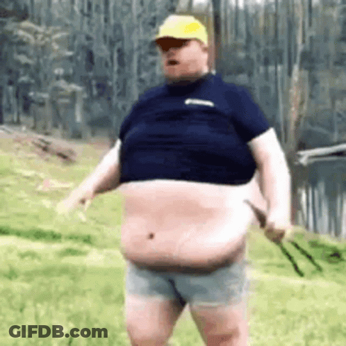 A Fat Man In A Blue Shirt And Shorts Is Standing In The Grass . GIF