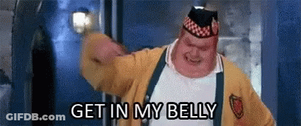 A Fat Man In A Yellow Jacket And Hat Is Saying `` Get In My Belly '' While Holding A Light . GIF