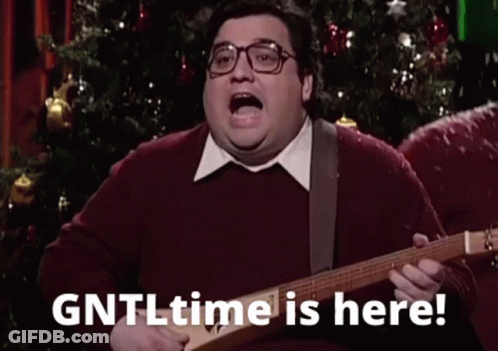 A Fat Man Is Playing A Guitar In Front Of A Christmas Tree And Saying `` Gntl Time Is Here '' . GIF