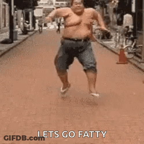 A Fat Man Is Running Down A Street Without A Shirt On . GIF