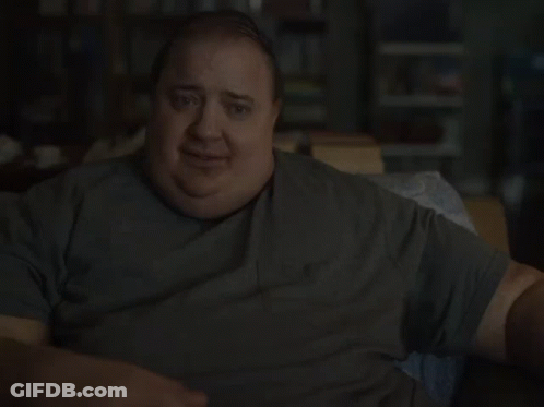 A Fat Man Is Sitting On A Couch And Smiling GIF