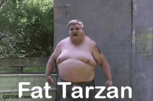 A Fat Man Is Standing In Front Of A Fence With The Words Fat Tarzan Written On It GIF