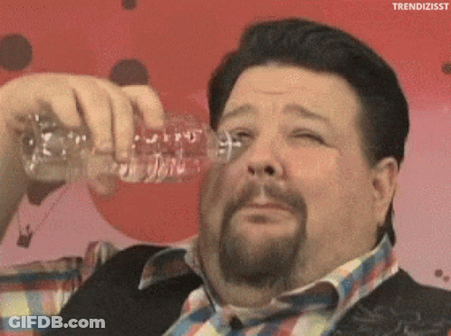 A Fat Man With A Beard Is Drinking Water From A Plastic Bottle GIF