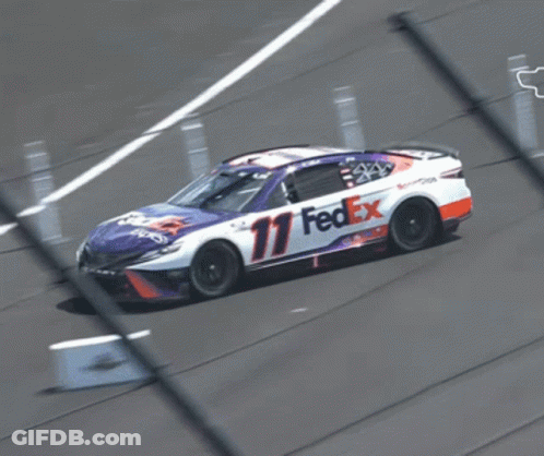 A Fedex Race Car Is Driving Down The Track GIF