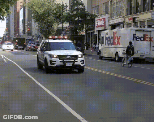 A Fedex Truck Is Driving Down The Street GIF