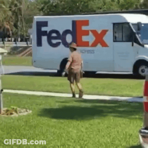 A Fedex Truck Is Parked In The Grass And A Man Is Walking In Front Of It GIF