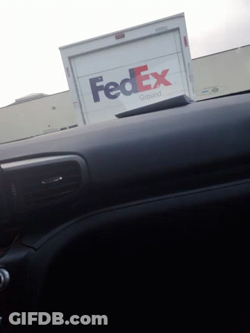 A Fedex Truck Is Parked On The Side Of A Building GIF