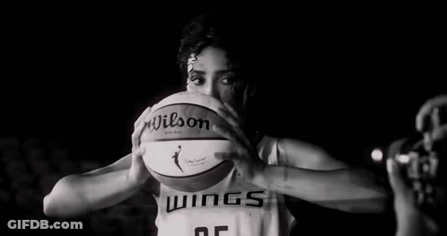 A Female Basketball Player Is Holding A Basketball In Front Of Her Face In A Black And White Photo . GIF