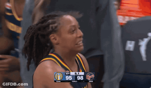 A Female Basketball Player Stands In Front Of A Scoreboard Showing The Score Of The Game Between Chi And Ind GIF