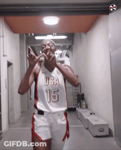 A Female Basketball Player Wearing A Usa 15 Jersey Is Giving A Peace Sign GIF