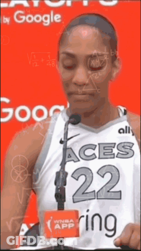 A Female Basketball Player With The Number 22 On Her Jersey Stands In Front Of A Microphone GIF