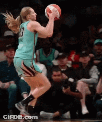 A Female Basketball Player With The Number 23 On Her Jersey Is Jumping To Catch The Ball GIF