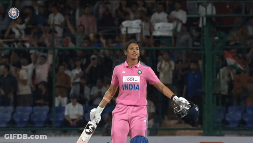 A Female Cricket Player In A Pink India Jersey Holds Her Bat GIF