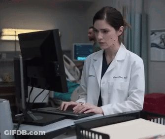 A Female Doctor In A Lab Coat Is Typing On A Keyboard GIF