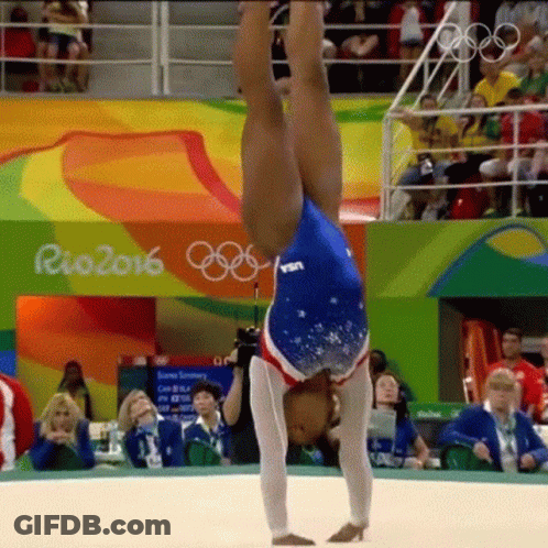 A Female Gymnast Is Doing A Handstand In Front Of A Crowd At Rio 2016 GIF