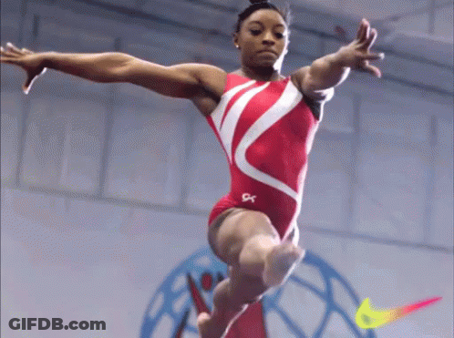 A Female Gymnast Is Doing A Trick On A Balance Beam With A Nike Logo In The Background GIF
