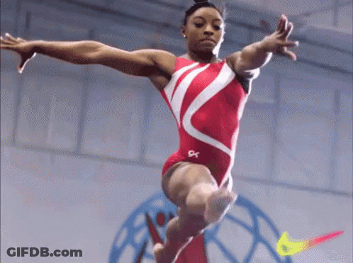 A Female Gymnast Is Doing A Trick On A Balance Beam With A Nike Logo In The Background GIF