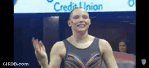 A Female Gymnast Is Waving Her Hand In Front Of A Sign That Says Credit Union GIF