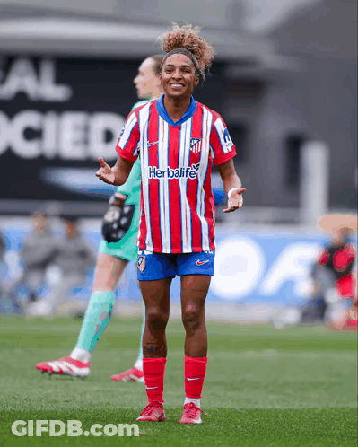 A Female Soccer Player Wearing A Red And White Striped Shirt With The Word Herbalife On It GIF