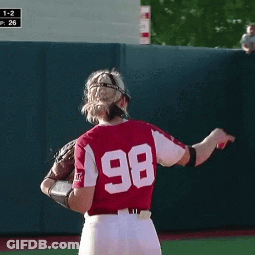 A Female Softball Player Wearing A Helmet And Glove With The Number 26 On Her Jersey GIF