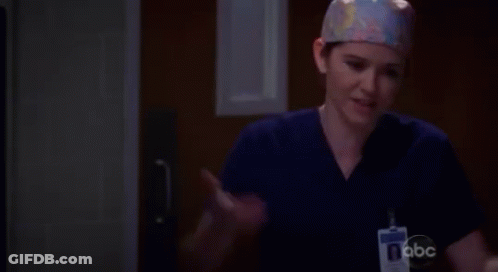 A Female Surgeon Wearing A Scrub Top And A Name Tag With Abc On It GIF