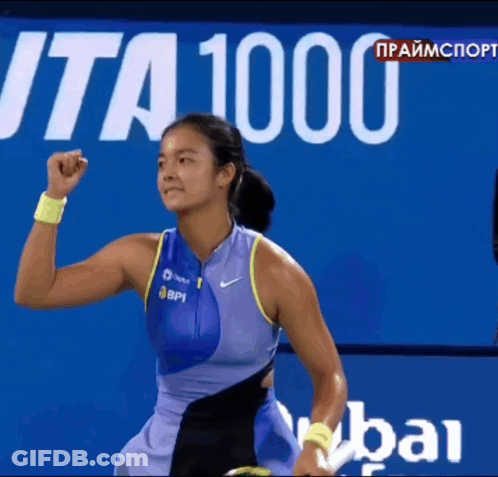 A Female Tennis Player Holds Her Fist In The Air In Front Of A Sign That Says " Ita 1000 " GIF