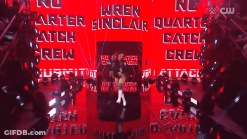 A Female Wrestler Named Wren Sinclair Is Standing In Front Of A Red Wall GIF